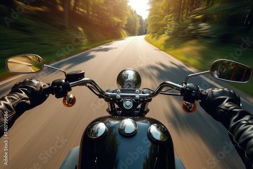 A modern biker driving down the road, blurred, low-angle, glossy finish. © Suwanlee