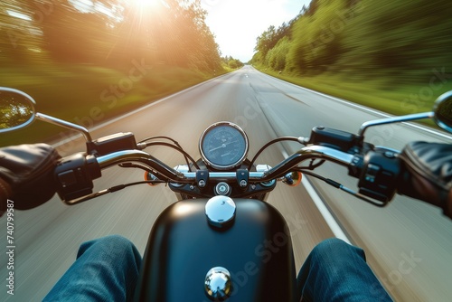 A modern biker driving down the road, blurred, low-angle, glossy finish.