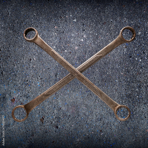 A crosssed pair of old boxend wrenches showing the patina of many years of use. photo