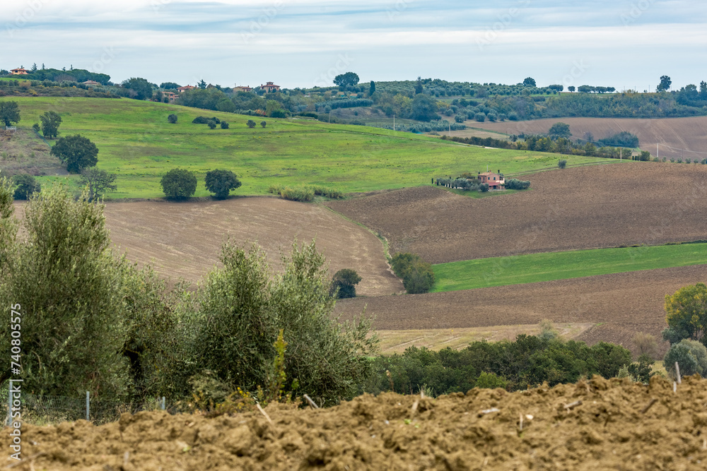 Obraz premium Autumn moody skies landscape in the mountain region of Tuscany, Italy with plowed fields, mist and beautiful cypress trees. Travel tourism destinations