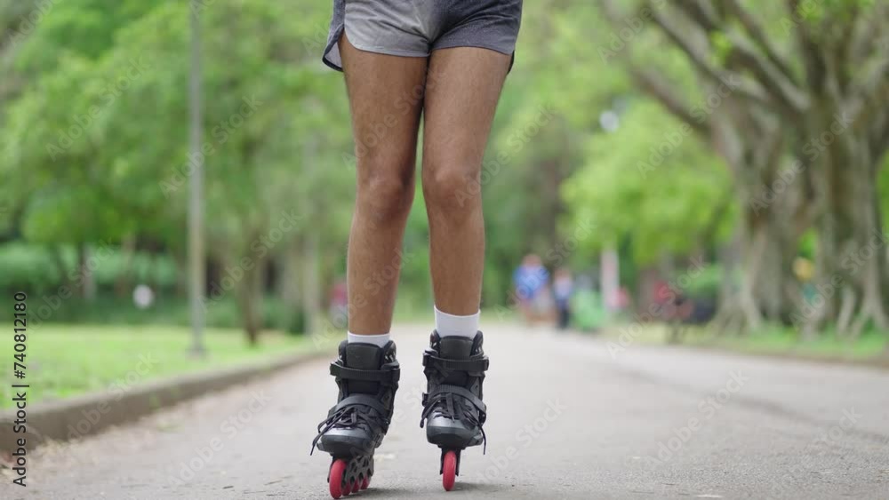 Portrait of queer man enjoying skating with roller skates and having fun at city park. Happy Genderqueer lgbt black man
