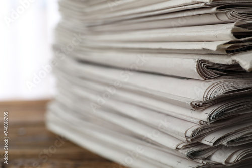 Stack of newspapers on wooden table, closeup. Journalist's work