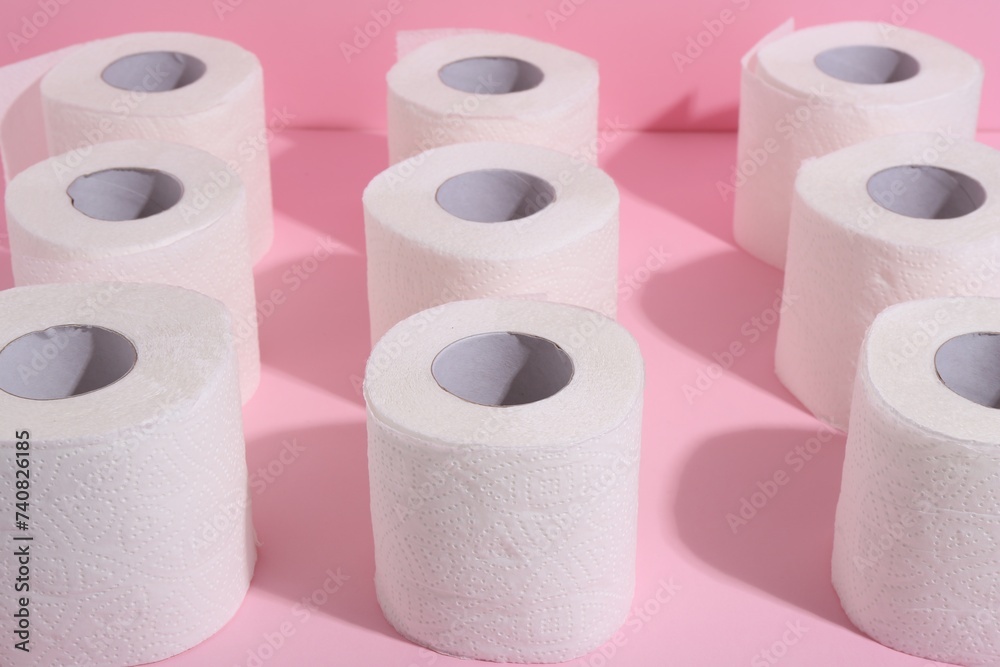 Many soft toilet paper rolls on pink background, closeup Many soft toilet paper rolls on pink background, closeup