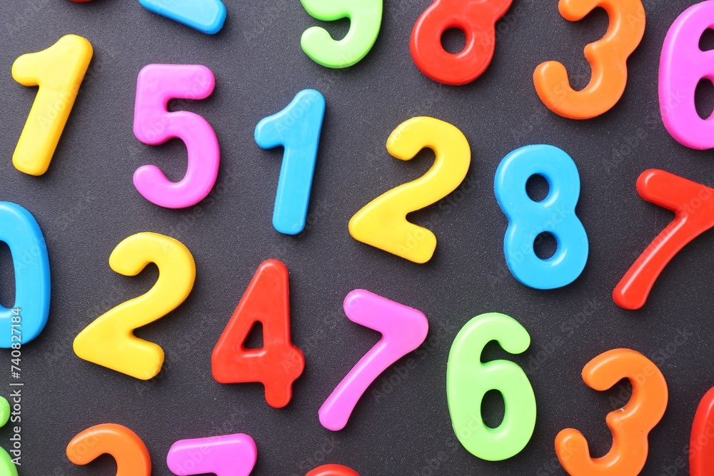 Naklejka premium Colorful numbers on dark gray background, flat lay