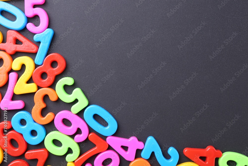 Colorful numbers on dark gray background, flat lay. Space for text Colorful numbers on dark gray background, flat lay. Space for text