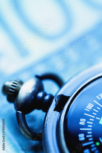 Compass against one hundred US Dollar bill background as symbol of moving in the right direction in business. Copy space for design or text. Vertical image.