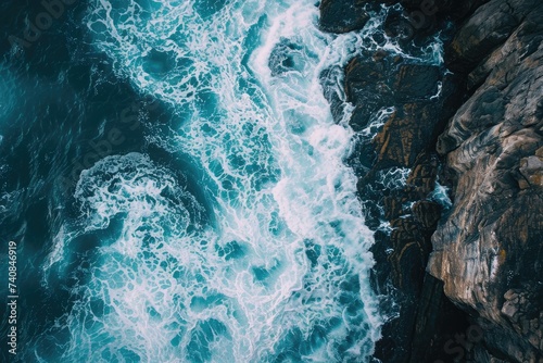 This photo captures an aerial view of the expansive ocean meeting the rugged rocks along the coast, Dramatic aerial shot of ocean waves beating against the magnificent rocks, AI Generated
