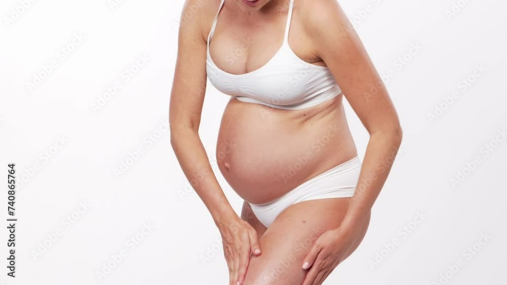 Young, happy and healthy pregnant woman in front of white background. Studio video. Baby expectation, pregnancy and motherhood. Young, happy and healthy pregnant woman in front of white background. Studio video. Baby expectation, pregnancy and motherhood.