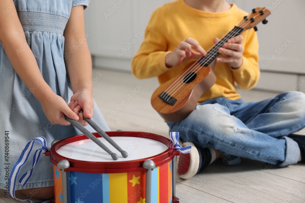 Fototapeta premium Little children playing toy musical instruments indoors, closeup