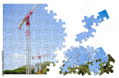 Metal tower crane, colored in white and red, against a blue background - solution concept in jigsaw puzzle shape photo