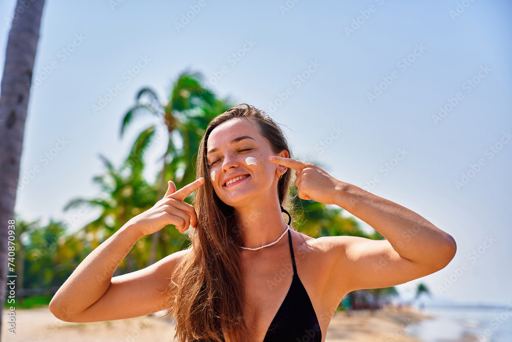 Portrait of satisfied young joyful happy smiling woman using facial spf sunscreen while sunbathing and relaxing in the sun. Sunburn protection and healthy skin Portrait of satisfied young joyful happy smiling woman using facial spf sunscreen while sunbathing and relaxing in the sun. Sunburn protection and healthy skin