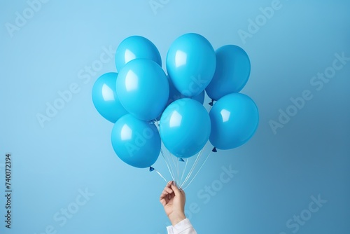 Hand holding blue balloon on blue background