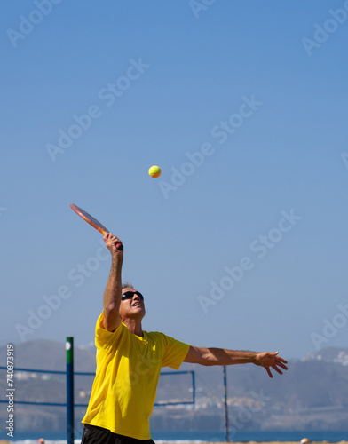 60 year old man playing beach tennis © Arianne