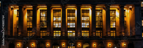 Illuminated neoclassical building facade at night in the city photo
