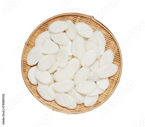 slice Tteok or slice Korean rice cake in wooden bowl isolated on white background. flat lay overhead