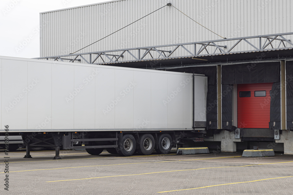 Row of red loading docks with containers of a warehouse or distbution center Row of red loading docks with containers of a warehouse or distbution center