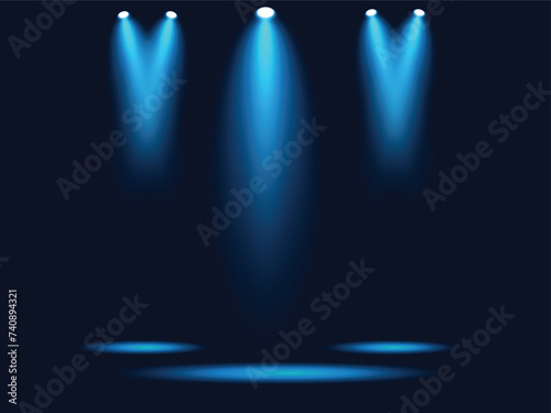 A dark stage with spotlight blue lights on the top