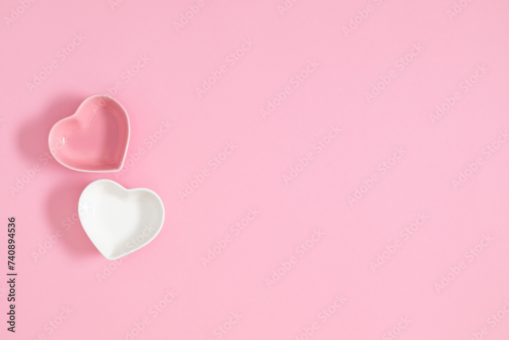 Valentine's Day composition with pair of ceramic hearts on pastel pink table. Flat lay, top view, copy space. 