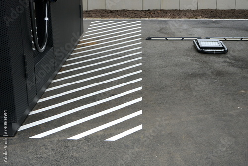 Weiß schraffierte Fläche für Fußgänger auf grauem Asphalt an der Ladestation für ein E-Auto auf dem Parkplatz der Klassikstadt im Stadtteil Fechenheim in Frankfurt am Main in Hessen