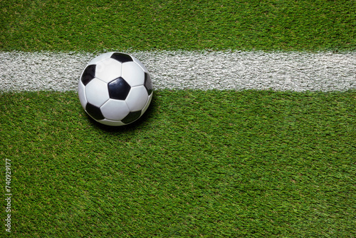 Soccer ball on grass field with stripe overhead view