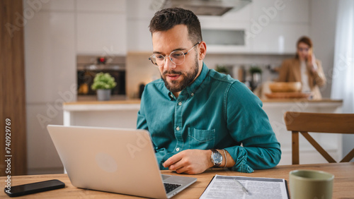 man adult caucasian WITH BEARD AND EYEGLASSES work on laptop at home