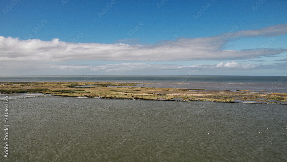 Idyllic scenic nature landscape scenery in Mississippi River delta with marsh, fisher boats, wildlife birds and animals, oil towers and horizon views