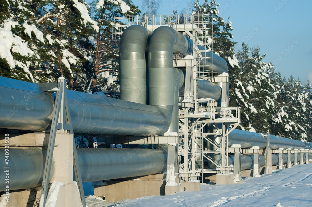 pipelines in winter against the backdrop of forest and blue sky pipelines in winter against the backdrop of forest and blue sky