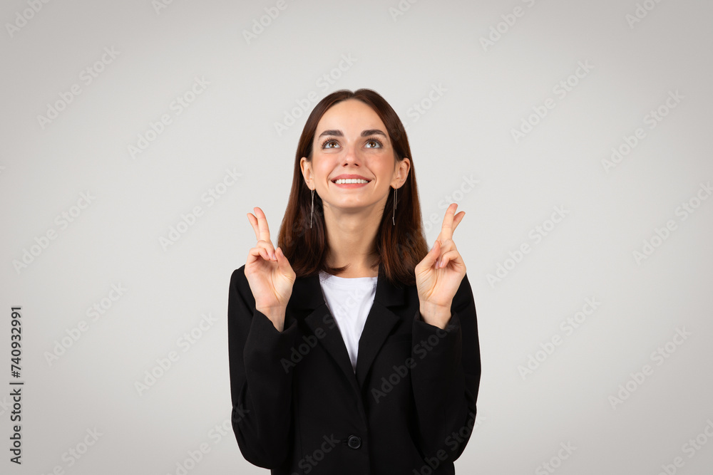 Smiling businesswoman in formal attire giving a thumbs-up as a sign of success, approval Smiling businesswoman in formal attire giving a thumbs-up as a sign of success, approval