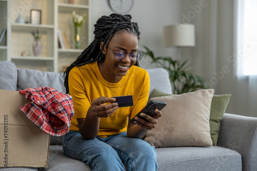 African american young woman buying something online and smiling