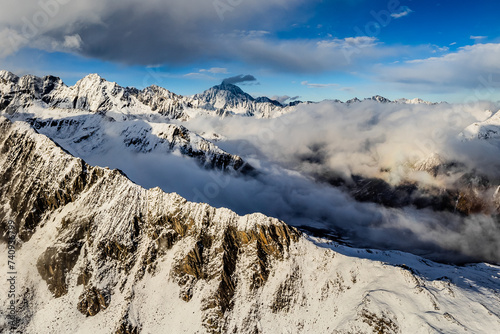 Bird's eye view from drone of snow mountain ridge and peak with cloud at sunset time at Dafeng base camp on the Siguniang Shan mountain in Changping Gou National Parks ,Rilong,Chengdu, China