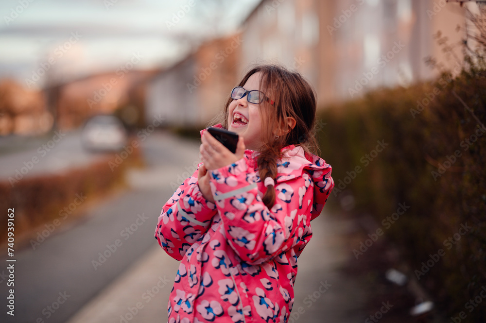 Delighted Young Girl Using Smartphone Outdoors with Excitement