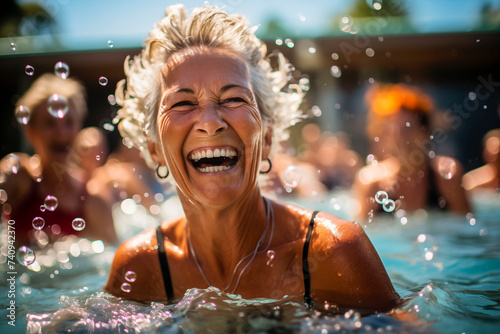 Elderly happy woman do aqua aerobics in the indoor pool © zebronit