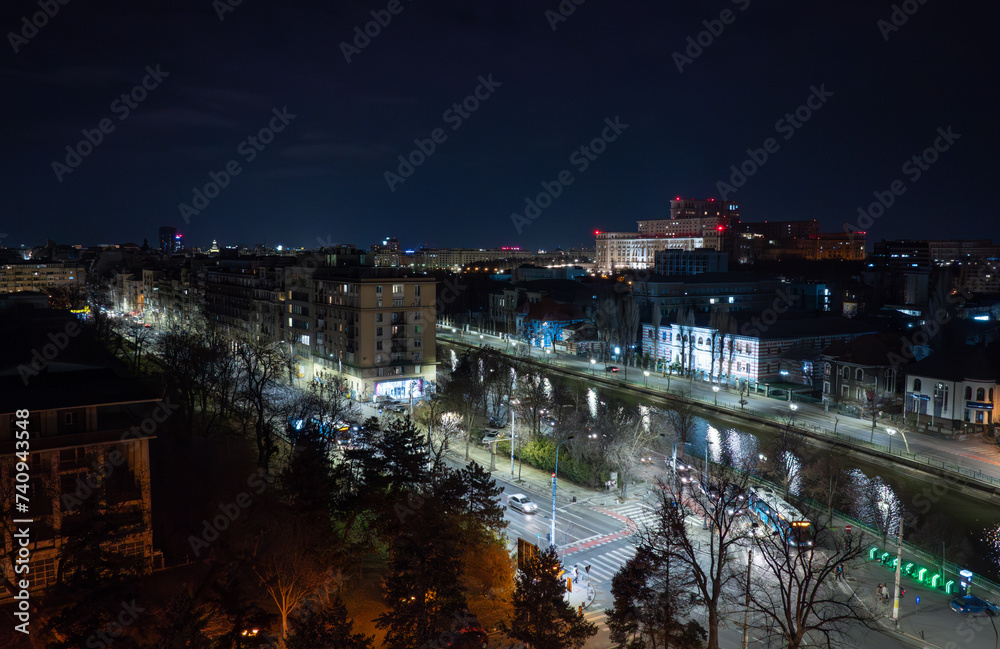 Fototapeta premium Bucharest from above by night. Aerial photo with the streets of Bucharest and the Palace of the Parliament during the evening. Travel to Romania.
