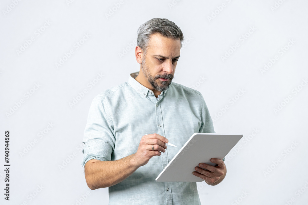 Bearded man holding and looking at tablet computer for online work isolated on white. Bearded man holding and looking at tablet computer for online work isolated on white.
