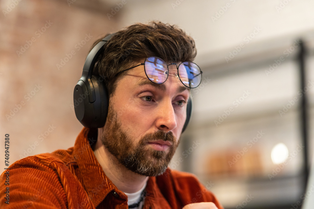 Bearded man sitting at laptop and looking tired after work Bearded man sitting at laptop and looking tired after work