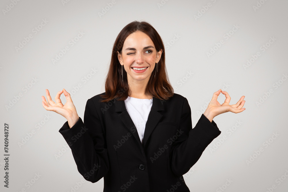 Positive businesswoman with a content smile making the 'okay' sign with both hands Positive businesswoman with a content smile making the 'okay' sign with both hands