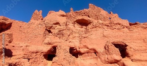 the remains of Ksar d'Ighzer, ruins of ancient stone and red clay houses, a village in the middle of the desert in the town of Timimoun, Algeria photo