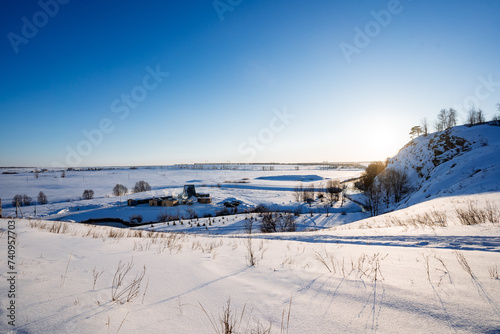 Beautiful winter landscape in hilly terrain, snowy expanses, mountain against blue sky, trekking in the mountains.