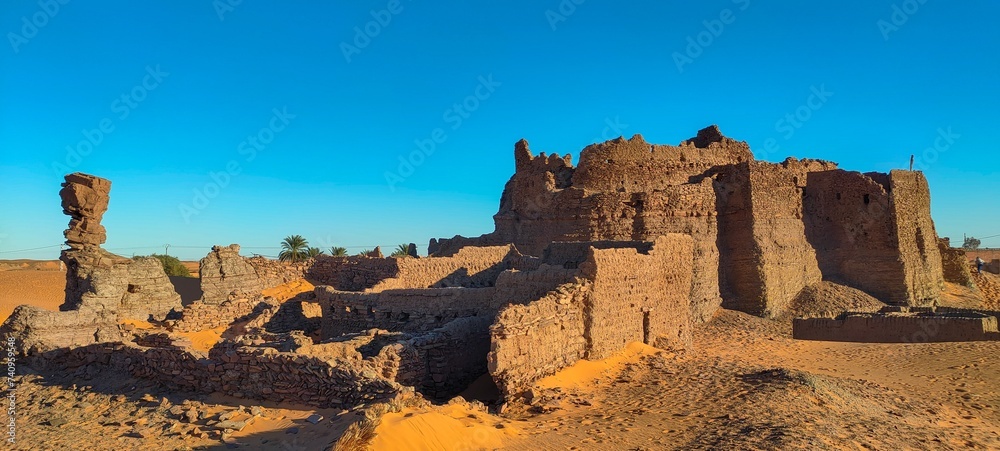 panoramic view of the remains of Ksour d'Aghlad, ruins of ancient castles made of stone and red clay in the middle of the desert in the town of Timimoun, Algeria