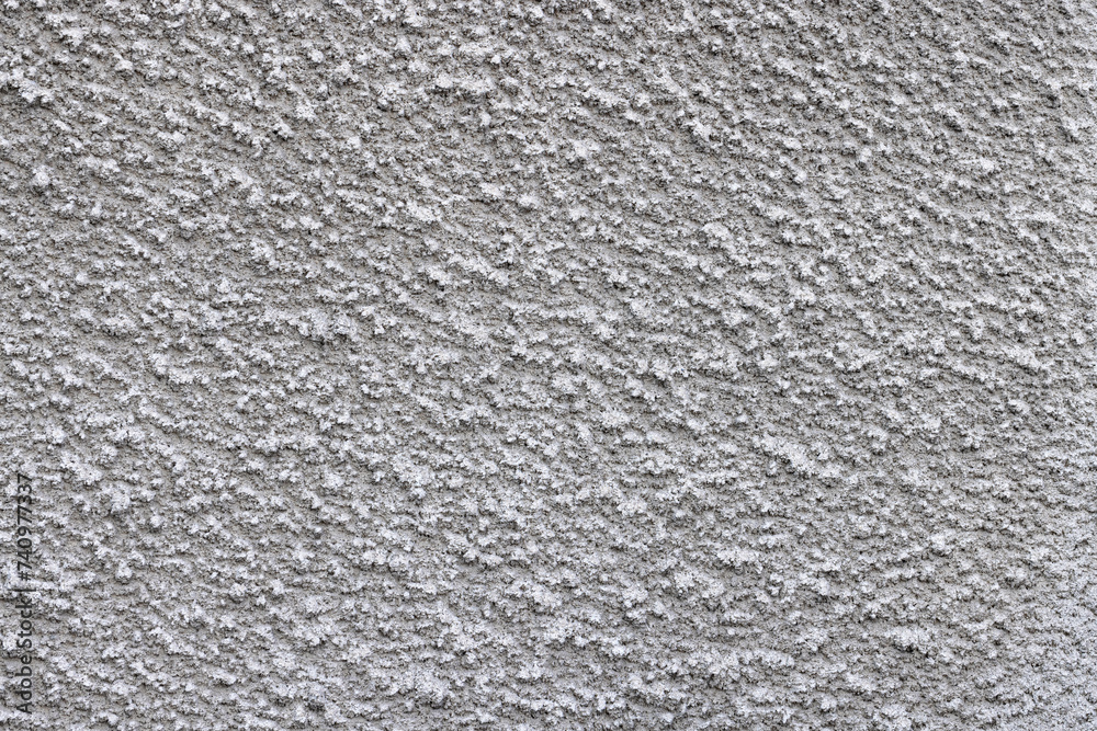 Texture of a gray cement wall with a pimply coating. Texture of a gray cement wall with a pimply coating.