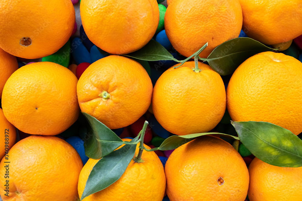 Ripe oranges with green leaves texture background Ripe oranges with green leaves texture background