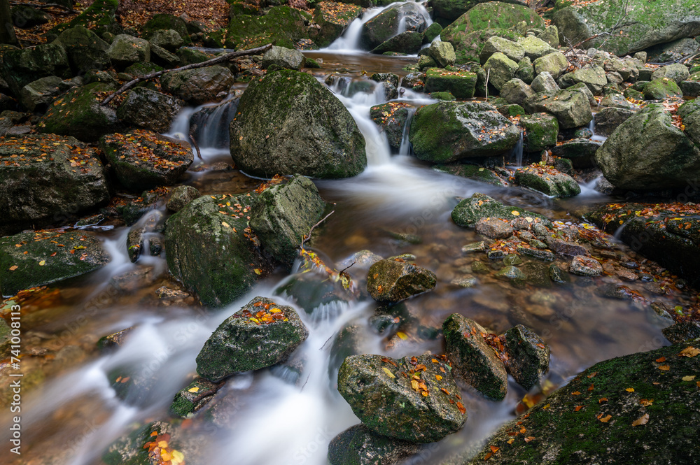 Mountain stream with waterfalls in the autumn forest with colorful leaves in the Jizera Mountains in the Czech Republic Mountain stream with waterfalls in the autumn forest with colorful leaves in the Jizera Mountains in the Czech Republic