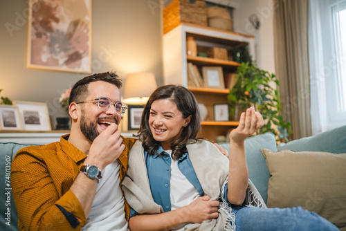 Couple caucasian man and woman sit at home on sofa bed watch tv movie photo