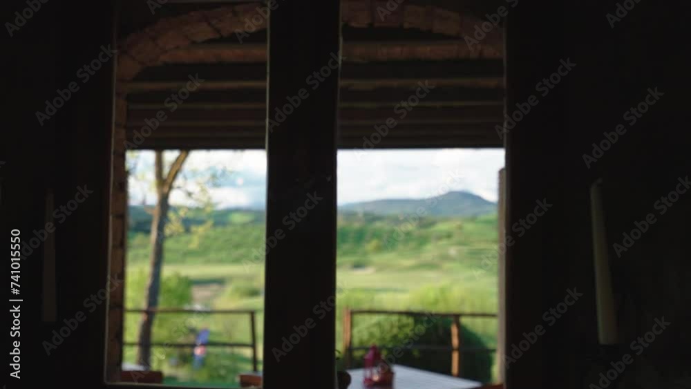 View from inside of stone restaurant window on amazing nature landscape in Toscana region, beautifully mowed lawn and mountains covered with clouds, tables and chairs for guests on terrace, amazing View from inside of stone restaurant window on amazing nature landscape in Toscana region, beautifully mowed lawn and mountains covered with clouds, tables and chairs for guests on terrace, amazing