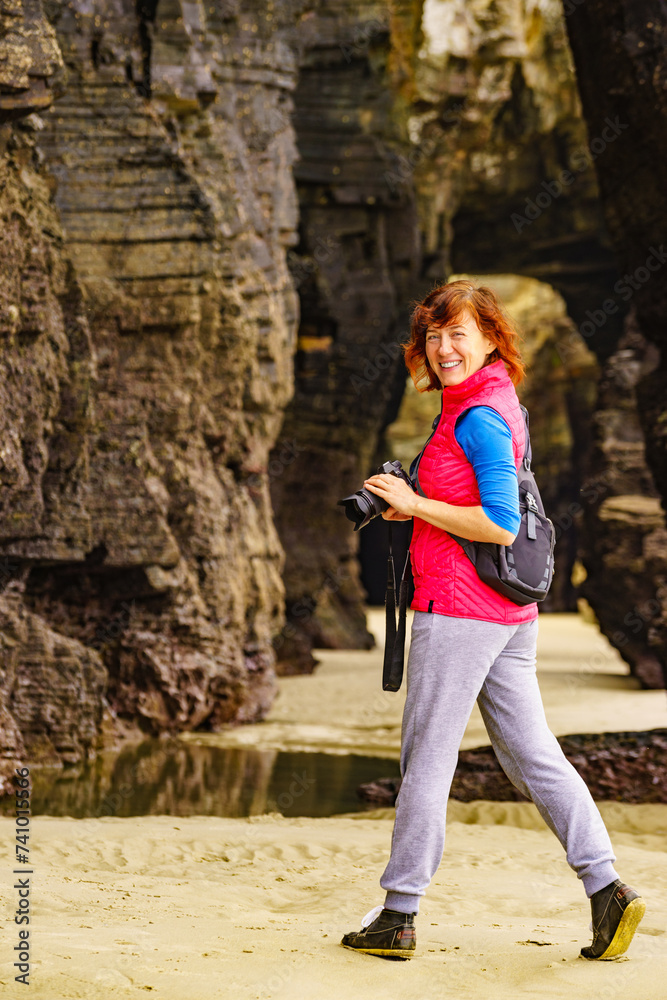 Woman with camera at Cathedral Beach, Galicia Spain.