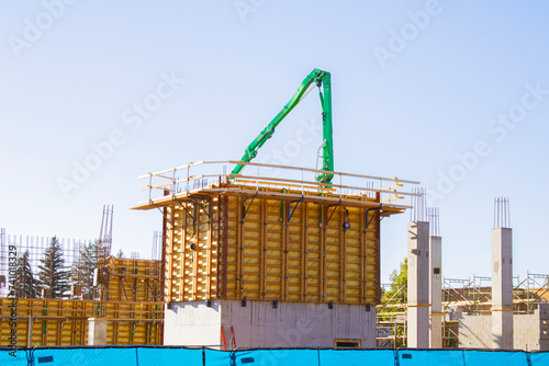 building under construction with green crane