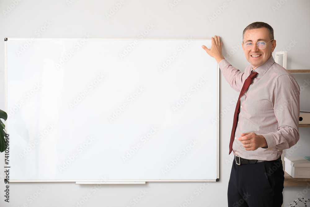 Male teacher near flipboard in classroom Male teacher near flipboard in classroom