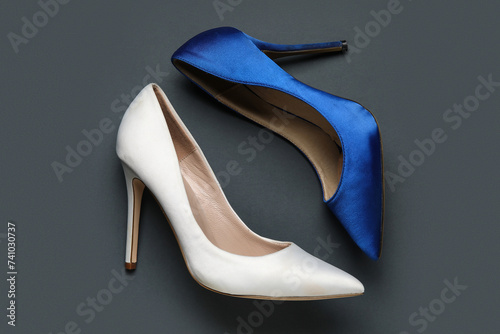 Different stylish high heels on grey background