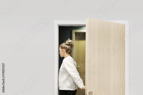 woman opening the door of her home.