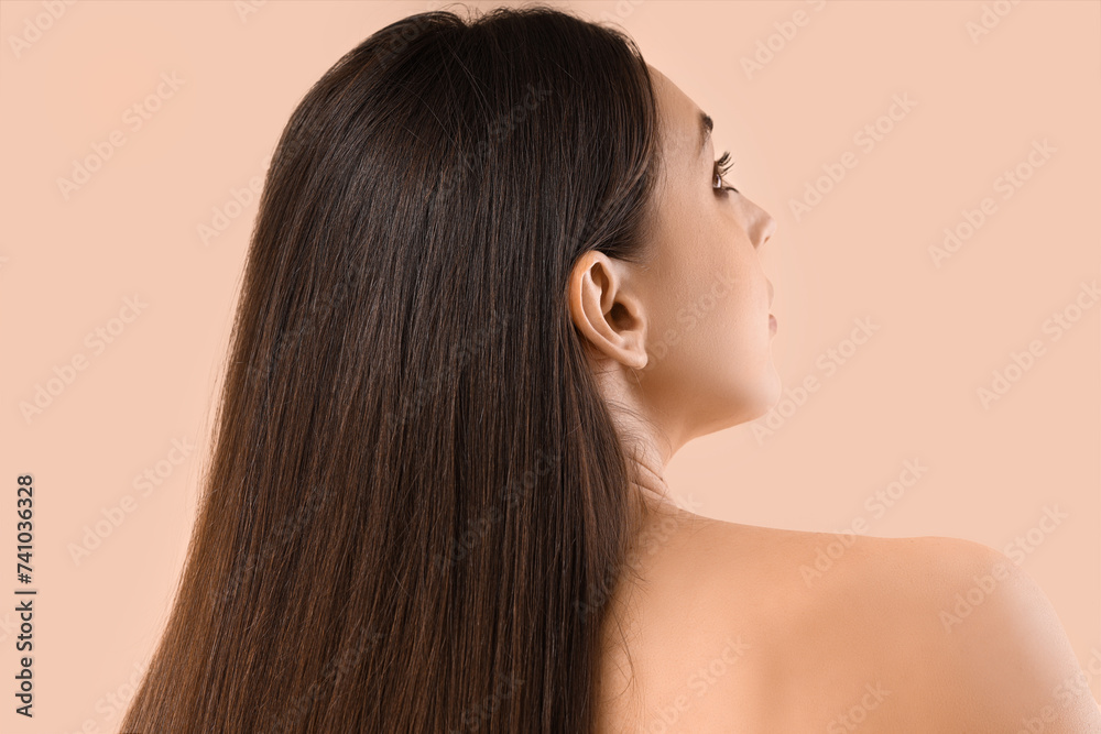 Young brunette woman with beautiful hair on beige background, back view Young brunette woman with beautiful hair on beige background, back view